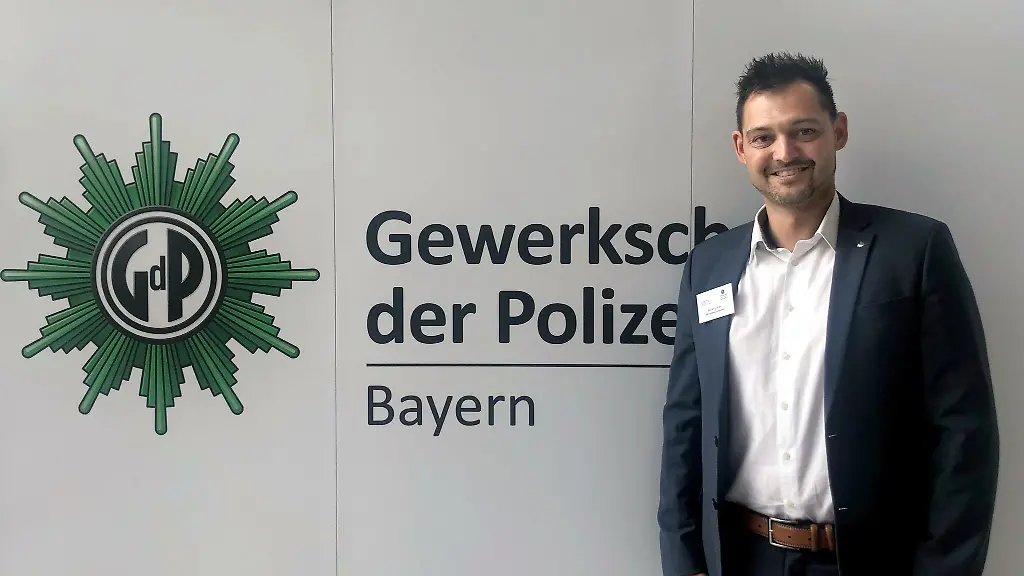 Florian-Leitner-aus-Erding-ist-der-neue-Vorsitzende-der-Gewerkschaft-der-Polizei-GdP-in-Bayern-und-steht-beim-Landesdelegiertentag-in-Bad-Goegging-bei-Neustadt-an-der-Donau-vor-einem-Schriftzug-Leitner-wurde-am-Mittwoch-beim-Landesdelegiertentag-gewaehlt