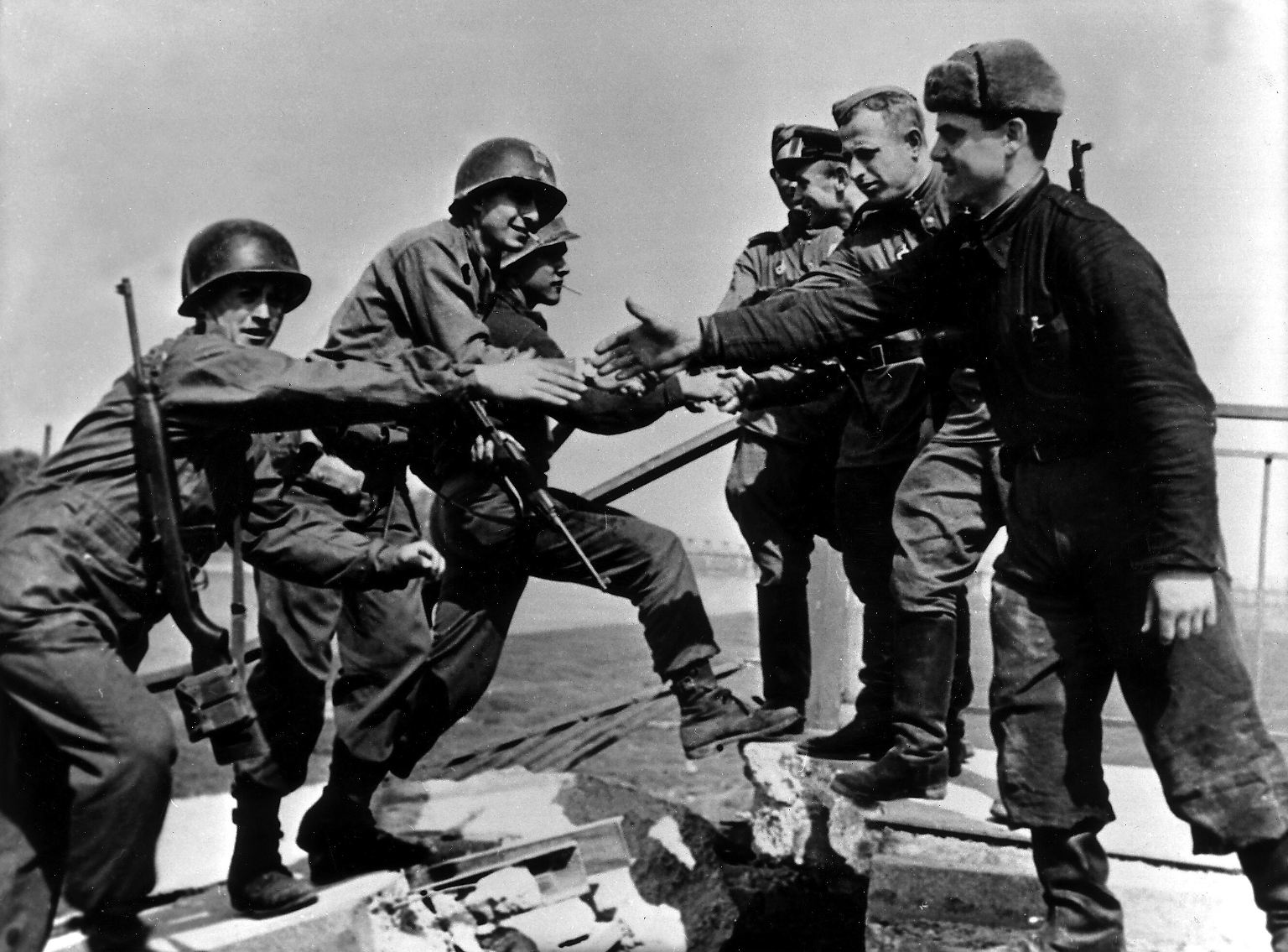Auf der zerstörten Elbbrücke in Torgau begrüßen sich am 25. April 1945 drei amerikanische und vier sowjetische Soldaten fast wie alte Freunde.