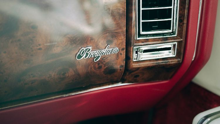 Auf dem Wurzelholz-Dekor der Armaturentafel prangt noch ein Brougham-Schriftzug, damit die Passagiere auch wissen, wo sie drinsitzen.