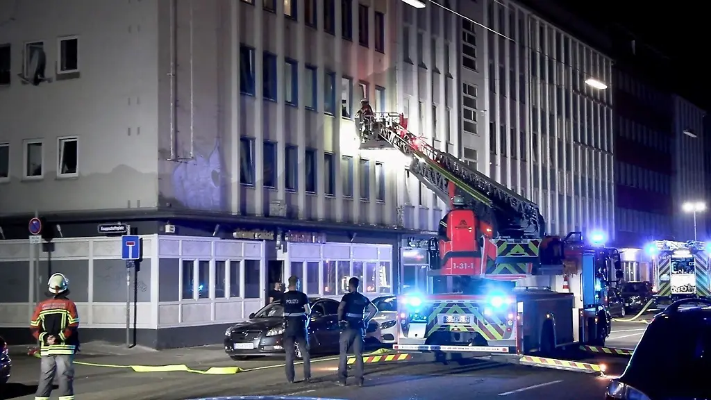 Feuerwehrleute-loeschen-einen-Brand-in-einem-Mehrfamilienhaus