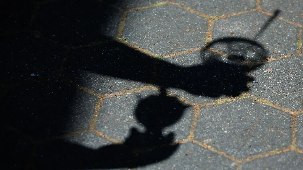 Haende-die-zwei-Eisbecher-halten-werfen-ihren-Schatten-auf-den-Gehweg-vor-einer-Eisdiele