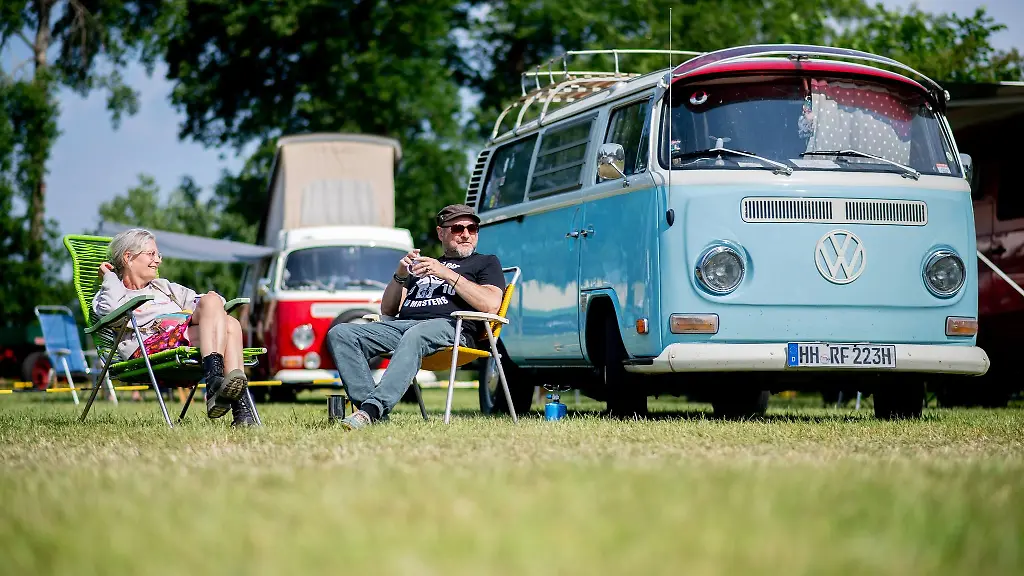 Christine-und-Ralf-sitzen-auf-dem-Bockhorner-Oldtimermarkt-vor-ihrem-Volkswagen-T2-aus-dem-Jahr-1972