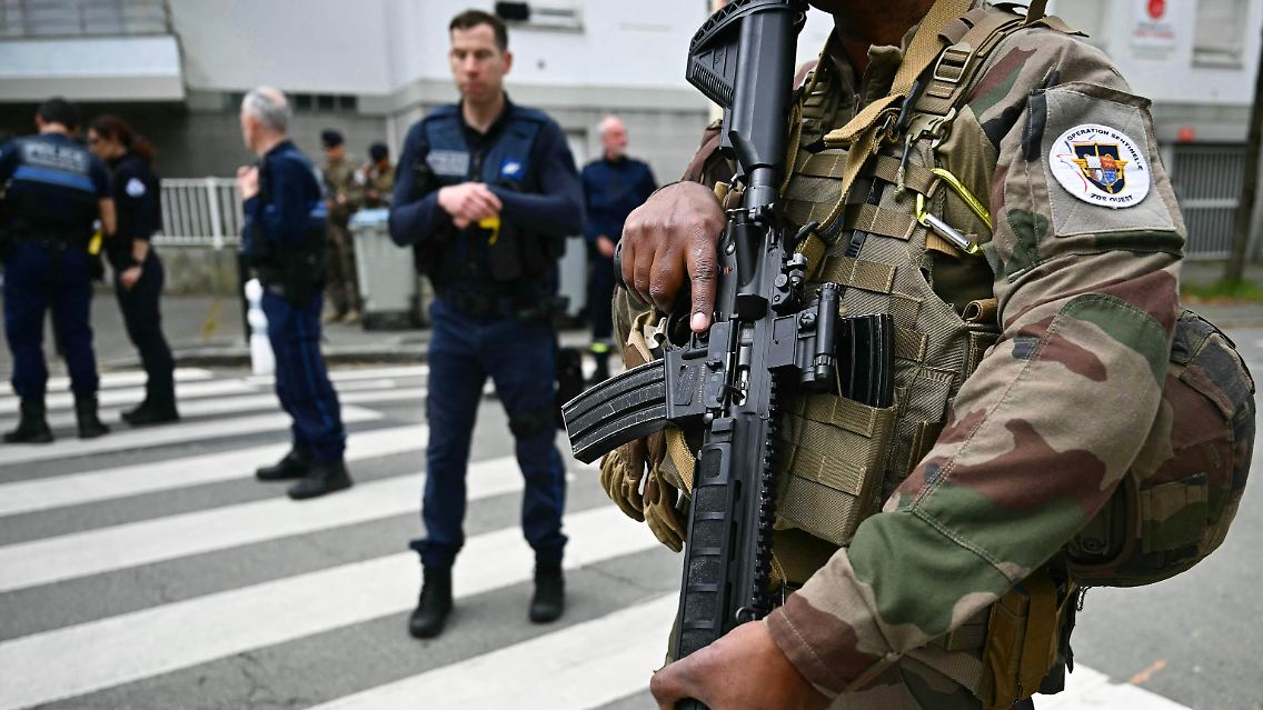 Französische Militärs der Operation Sentinelle, französische Polizisten und Beamte der Stadtpolizei stehen in der Nähe des Gymnasiums.