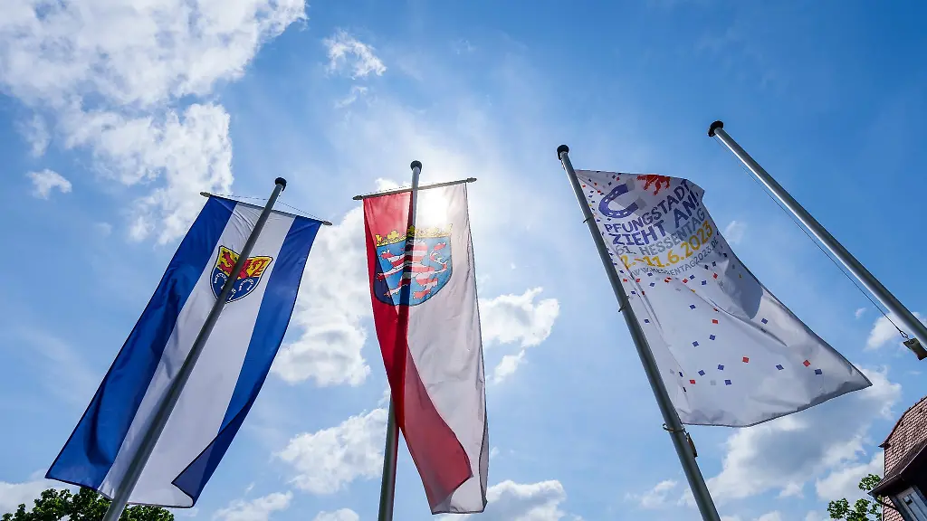 Das-Wappen-von-Pfungstadt-l-r-der-Hessen-Loewe-und-die-Hessentags-Flagge-wehen-in-der-Innenstadt-im-Wind