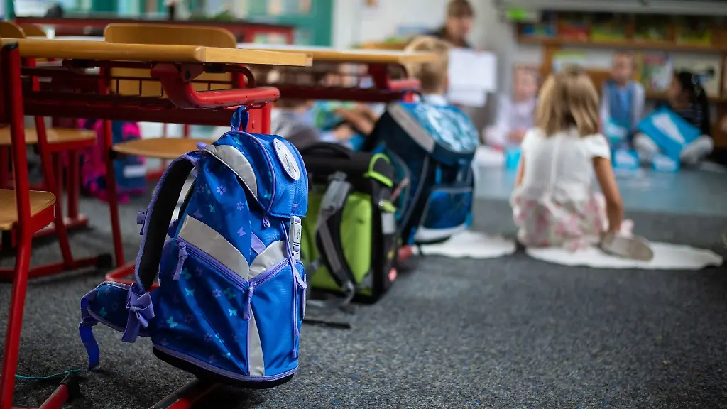 Ranzen-haengen-und-stehen-beim-Begruessungsunterricht-fuer-neue-Erstklaessler-in-einem-Klassenzimmer