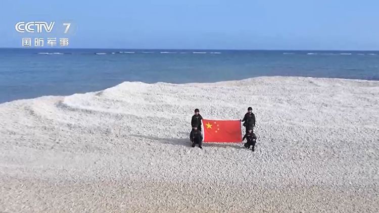 Angehörige der chinesischen Küstenwache mit ihrer Fahne auf Sandy Cay.