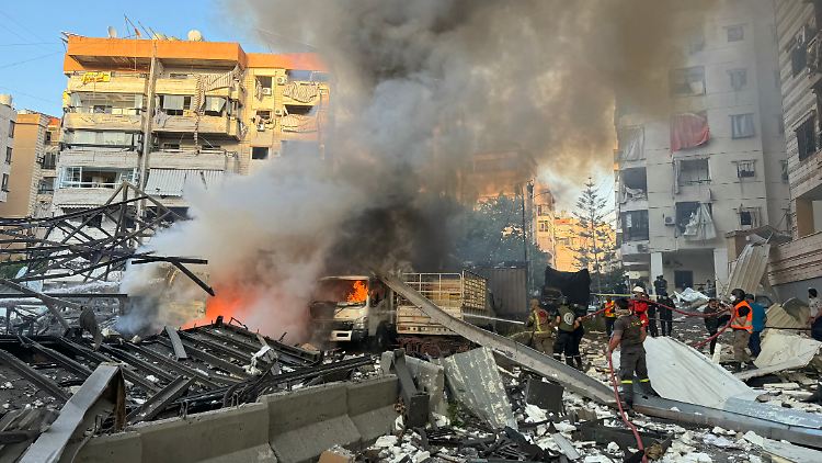 Rettungskräfte löschen ein Feuer nach dem Angriff. 