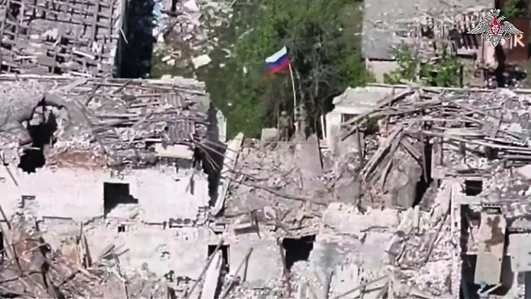 Die russische Fahne weht über Trümmern in der ukrainischen Region Charkiw.