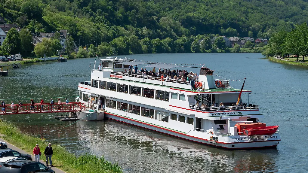 Touristen-verlassen-nach-einer-Rundfahrt-auf-der-Mosel-am-Anlegesteg-das-Motorschiff-Moselprinzessin