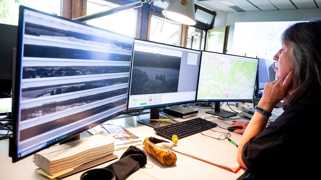 Eine-Mitarbeiterin-der-Waldbrandzentrale-Lueneburg-sitzt-vor-Bildschirmen-und-schaut-sich-Kamerabilder-an