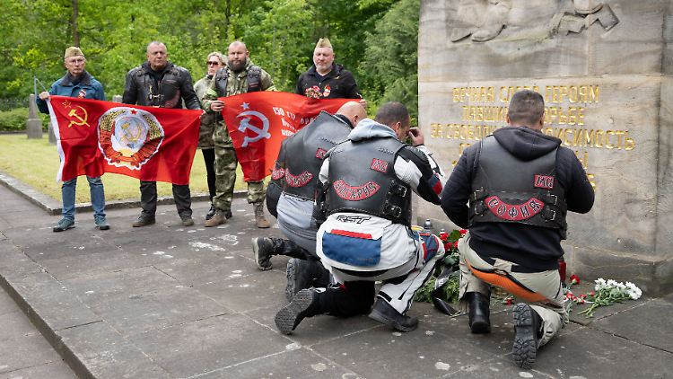 Mitglieder der "Nachtwölfe" knien auf dem Sowjetischen Garnisonsfriedhof vor dem Obelisk von Friedrich Press.