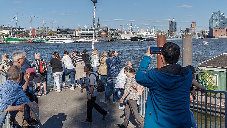 Touristen bestaunen den Hamburger Hafenbereich.