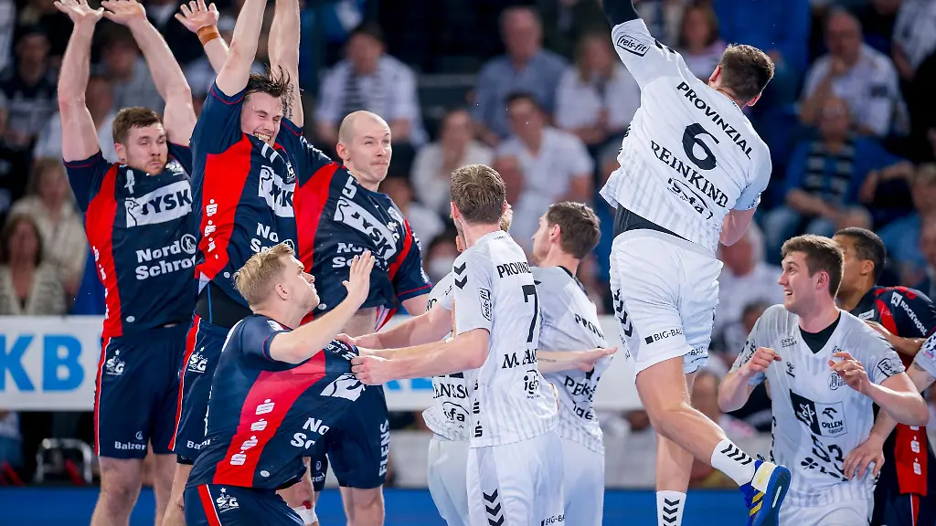 Die-SG-Abwehrspieler-Johannes-Golla-links-Magnus-Abelvik-Rød-Roed-und-Simon-Hald-Jensen-Mitte-rechts-steigen-zum-Blocken-des-Kieler-Werfers-Harald-Reinkind-in-die-Luft