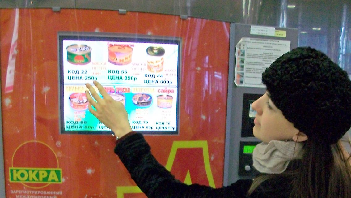 Eine junge Frau bedient in Moskau einen Kaviarautomaten.