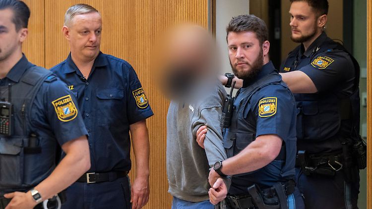 Einer der Angeklagten wird in den Verhandlungsaal im Oberlandesgericht München geführt. 