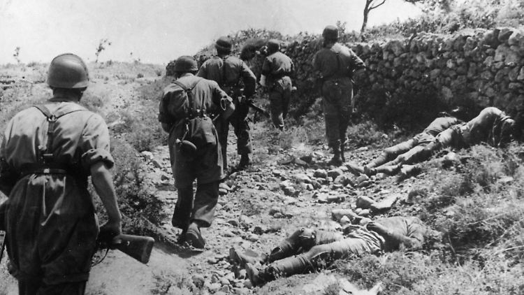 Deutsche Fallschirmjäger neben den Leichen britischer Soldaten auf Kreta.