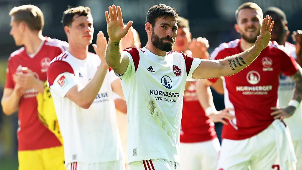 Nuernbergs-Enrico-Valentini-M-und-seine-Teamkollegen-jubeln-nach-dem-Spiel-mit-den-mitgereisten-Fans-ueber-den-Klassenerhalt