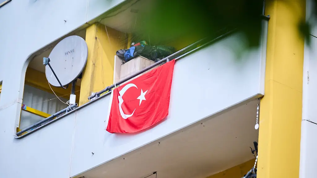 Auf-einem-Balkon-haengt-eine-tuerkischen-Flagge