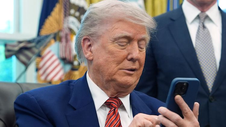 Das klingelnde Handy unterbrach Trump gleich zweimal, als er die Dekrete unterzeichnete.