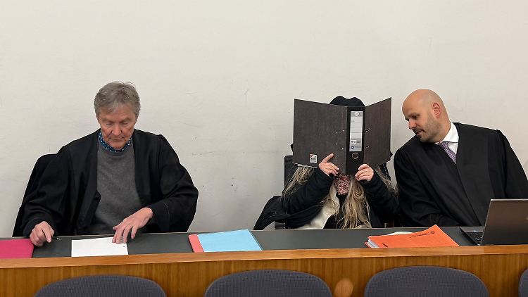 Die Angeklagte sitzt im Verhandlungssaal des Landgerichts zwischen ihren Verteidigern. 