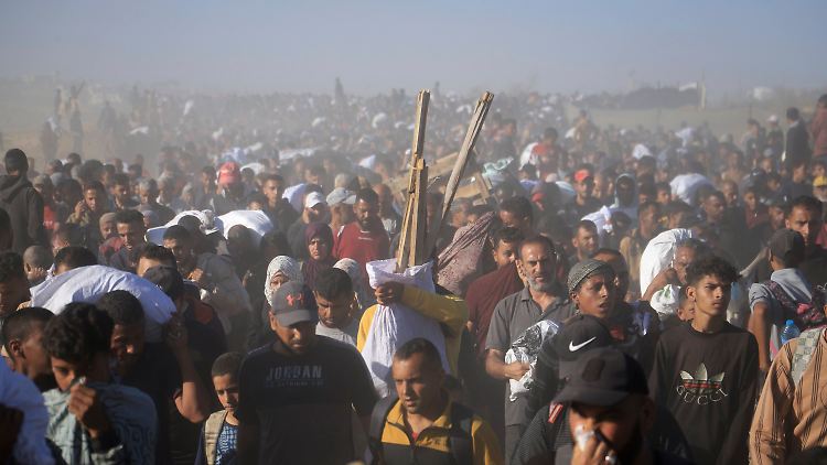Palästinenser tragen Kisten und Taschen mit Lebensmitteln und humanitären Hilfspaketen, die von der Gaza Humanitarian Foundation in Rafah geliefert wurden. 