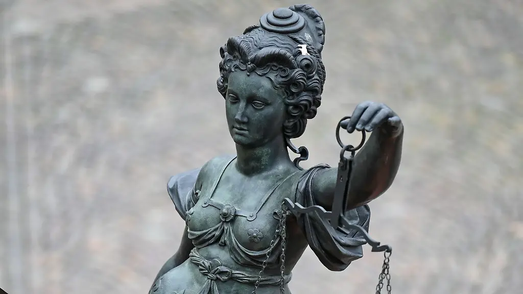 Eine-Statue-der-Justitia-haelt-eine-Waage-und-ein-Schwert-in-der-Hand