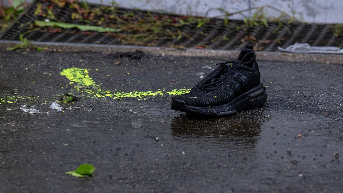 Ein Schuh steht auf dem Gehweg.