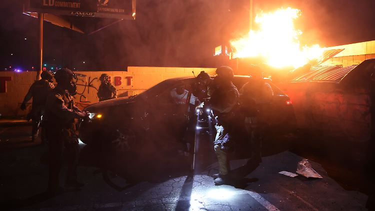 Polizisten helfen einer Person aus einem Auto, in der Nähe einer Demonstration in Compton, Kalifornien.
