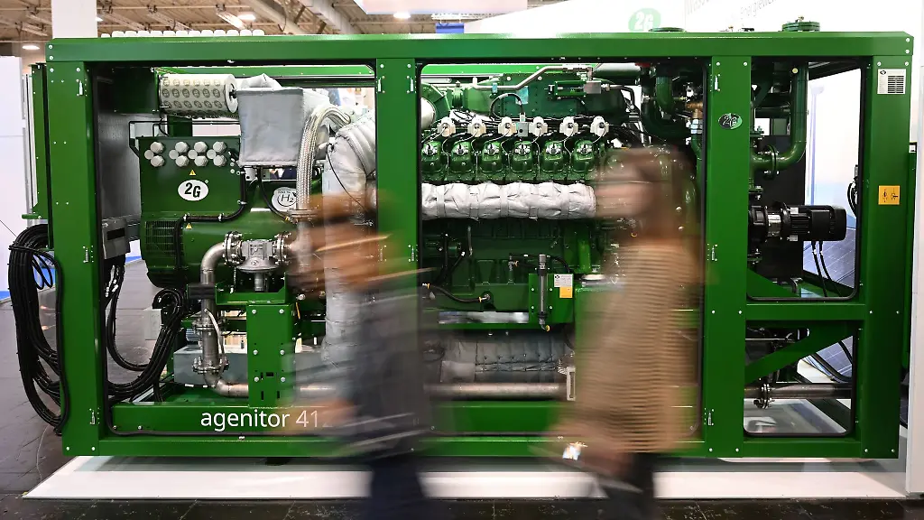 Messebesucher-gehen-an-einem-Blockheizkraftwerk-agenitor-412-der-2G-Energy-AG-vorbei