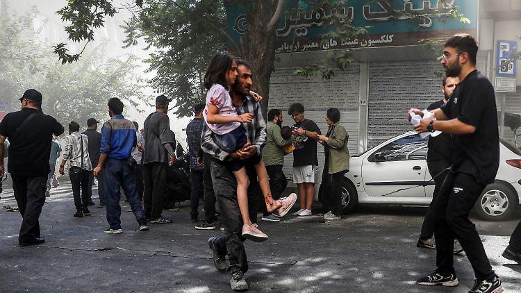 Ein Mann trägt ein verwundetes Mädchen nach einer Explosion in der Innenstadt von Teheran.