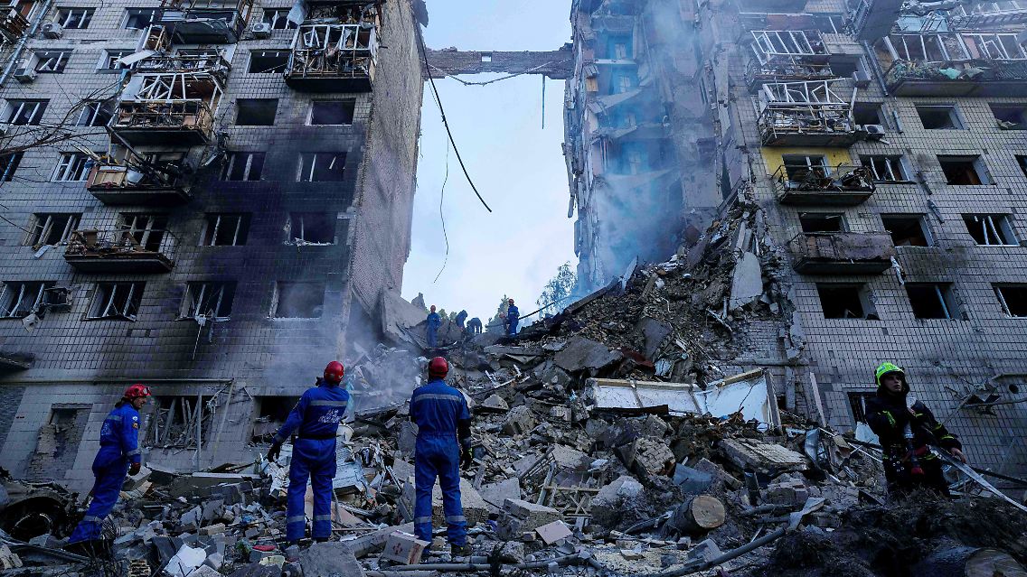 Rettungskräfte räumen die Trümmer an einem Wohnhaus nach einem Raketeneinschlag in Kiew.