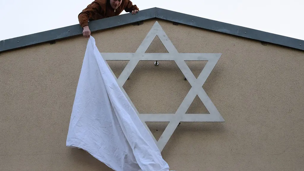 Ein-Mitglied-der-juedischen-Gemeinde-enthuellt-einen-Davidstern-an-der-Aussenwand-des-Domizils-der-Juedischen-Kultusgemeinde