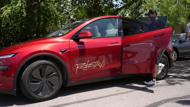 Ein Fahrgast steigt in ein fahrerloses Tesla-Robotaxi in Texas ein.