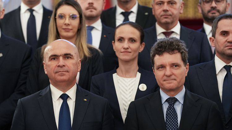 Der rumänische Präsident Nicusor Dan (r) und Ministerpräsident Ilie Bolojan (l) posieren für ein Foto mit der neuen Regierung nach einer Vereidigungszeremonie im Präsidentenpalast Cotroceni.