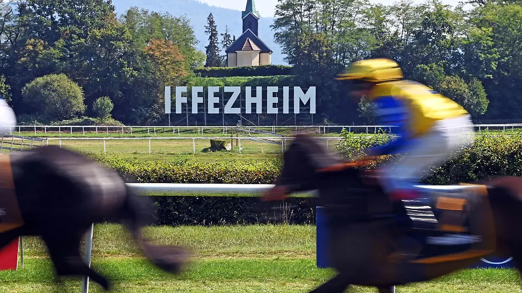 Bei-der-Grossen-Woche-auf-der-Galopprennbahn-Iffezheim-laufen-Reiter-vom-Gelaeuf