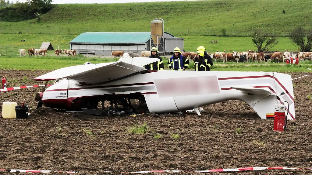 Feuerwehrleute-stehen-neben-einem-Kleinflugzeug-das-sich-ueberschlagen-hat