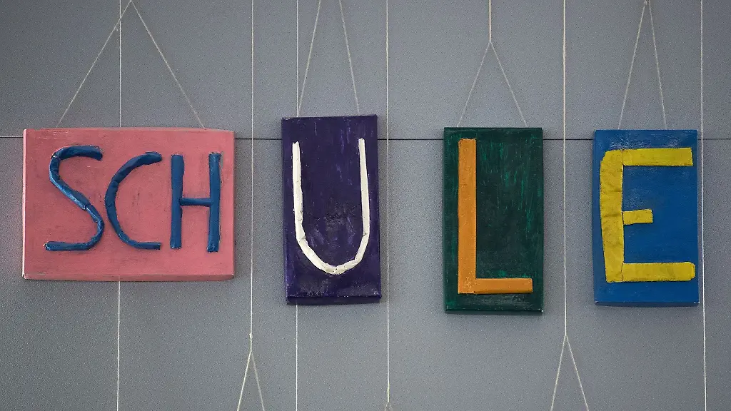 An-einer-Wand-in-der-Aula-einer-Grundschule-haengt-der-Schriftzug-Schule