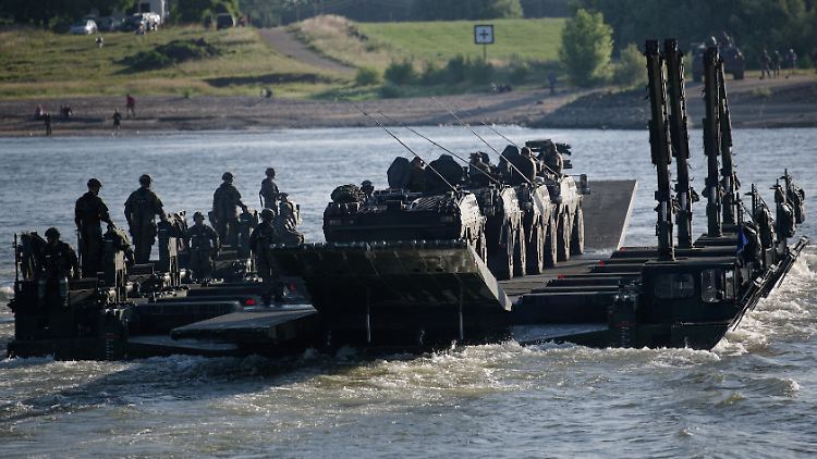 Eine aus Amphibienfahrzeugen gebildete Fähre transportiert Fahrzeuge über den Rhein. 