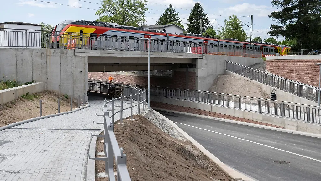 Ein-Zug-faehrt-ueber-die-neu-gebaute-Strasse