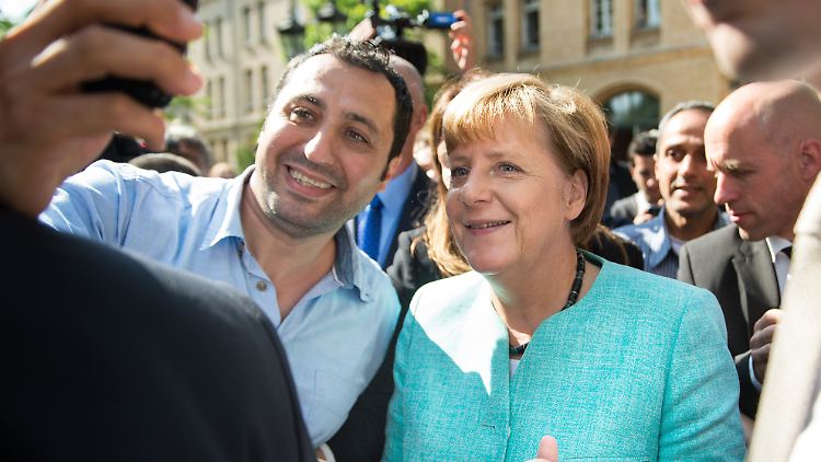 Im September 2015 besucht die damalige Kanzlerin Merkel eine Erstunterkunft in Berlin