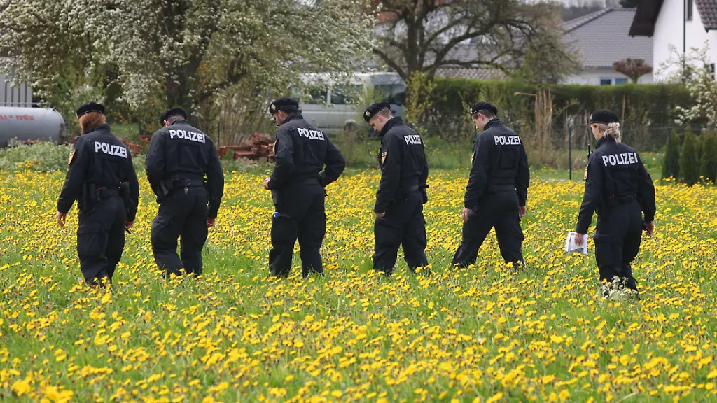 Polizisten-der-Bereitschaftspolizei-durchstreifen-eine-Wiese-auf-der-Suche-nach-Spuren-in-Altenstadt