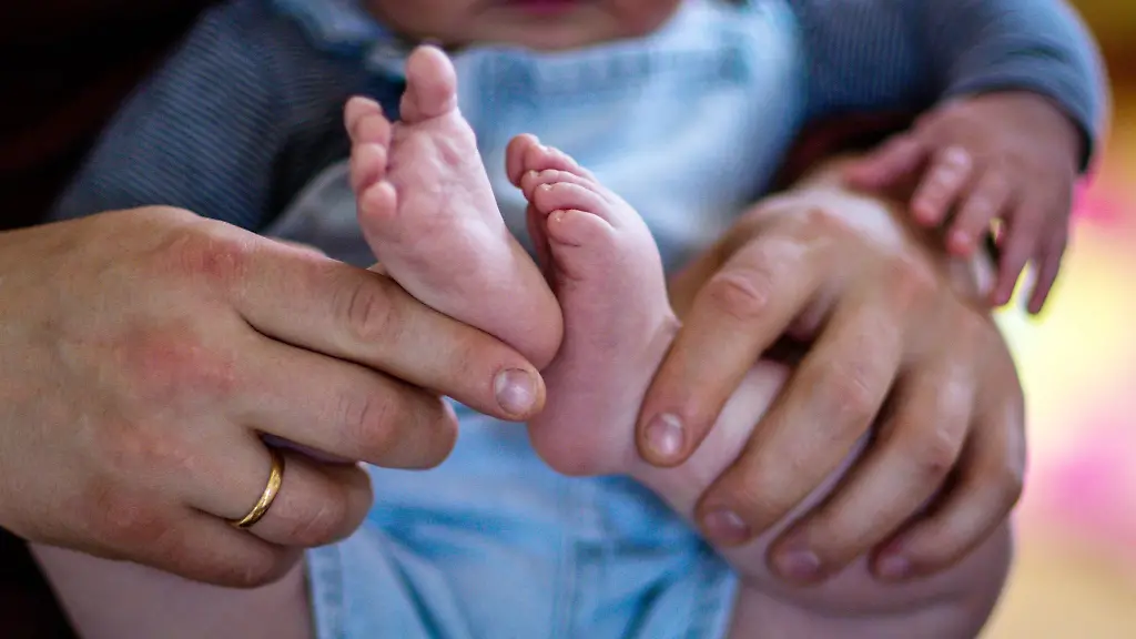 Ein-junger-Vater-spielt-mit-seinem-sechs-Monate-alten-Sohn