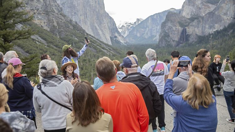 Eine Parkwächterin unterhält sich im Yosemite-Nationalpark mit Besuchern. 