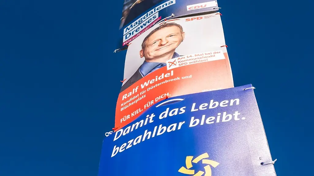Wahlplakate-von-AfD-CDU-SPD-und-dem-SSW-zur-Kommunalwahl-in-Schleswig-Holstein-haengen-an-einem-Laternenmast
