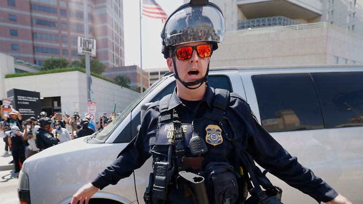 Proteste gegen Trumps Migrationspolitik: Ein Polizist des US-Ministeriums für Innere Sicherheit hält Demonstranten zurück, als ein Lieferwagen in das Metropolitan Detention Center in Los Angeles einfährt.