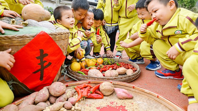Kinder aus einem chinesischen Kindergarten lernen bei einer Veranstaltung spielerisch die Arbeit in der Landwirtschaft kennen.