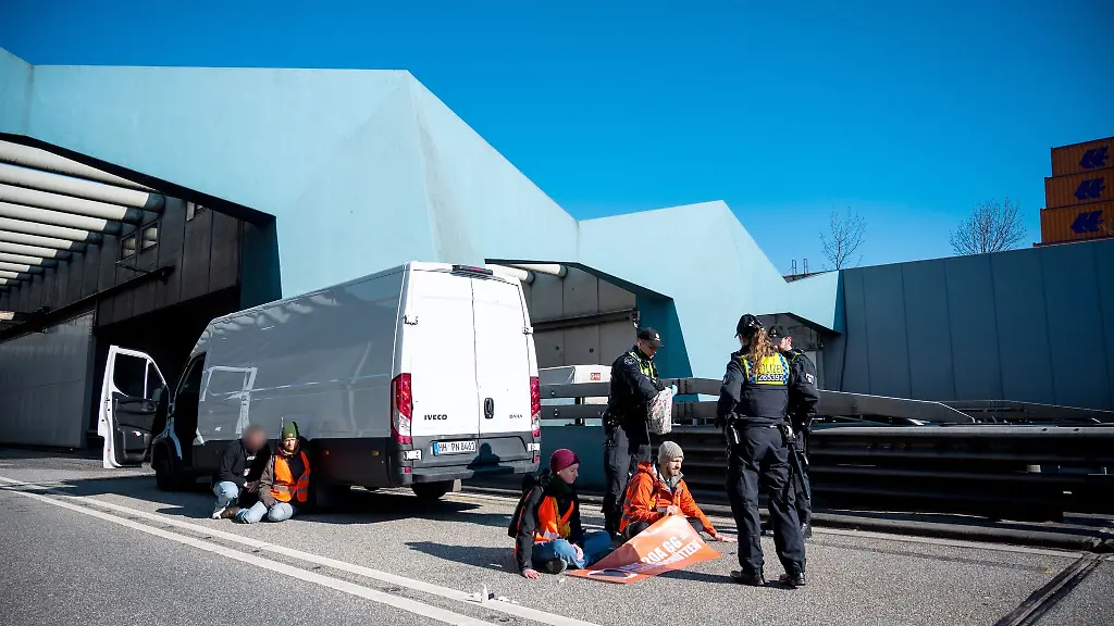 Klimaaktivisten-haben-sich-auf-der-Fahrbahn-festgeklebt-und-blockieren-so-die-Autobahn