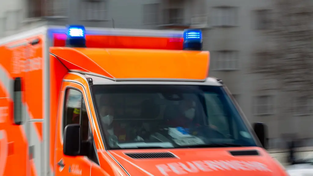 Ein-Rettungswagen-der-Feuerwehr-faehrt-auf-einer-Strasse