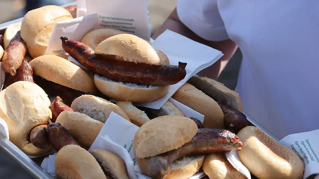 Gebratene-Rostbratwuerste-im-Broetchen-liegen-auf-einem-Tablett