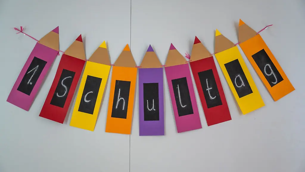 Ein-buntes-Bild-mit-der-Aufschrift-1-Schultag-haengt-im-Gang-einer-Grundschule-an-der-Wand